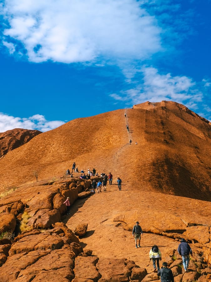 NT Australia - Tourist climbing Uluru from a different angle